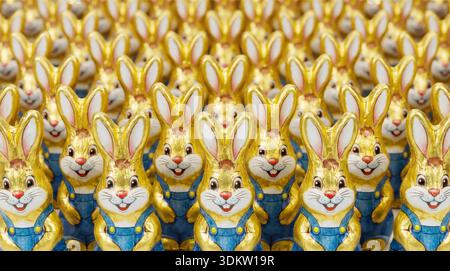 Viele Schokoosterhasen stehen dicht in mehreren Reihen Formatfüllendes Bild von Schokoosterhasen zum Thema Massenproduktion *** Many chocolate Easter bunnies standing close together in several rows Format-filling picture of chocolate Easter bunnies on the subject of mass production Stock Photo