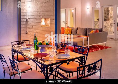Outdoor patio table set for evening night dining party chairs in backyard in Palm Springs, California Stock Photo