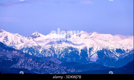 Majestic Snowy Mountain Range Under Clear Blue Sky With Winter Light Stock Photo