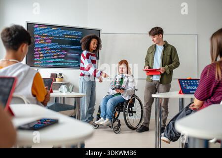Inclusive student team presenting technology project in class. Stock Photo