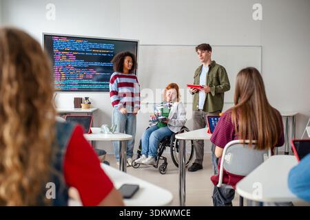Inclusive student team presenting technology project in class. Stock Photo