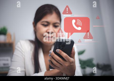 Asian woman using smartphone with red warning alert icons for scam call and phone fraud. Concept of cyber security, phishing, and protecting personal Stock Photo