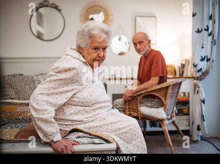 Elderly spouses sharing quiet moment before sleep. Stock Photo