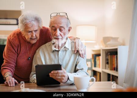 Senior coule working with tablet, having problem with technology. Stock Photo
