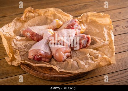 Raw chicken drumsticks on cutting board prepared  for cooking or barbecue Stock Photo