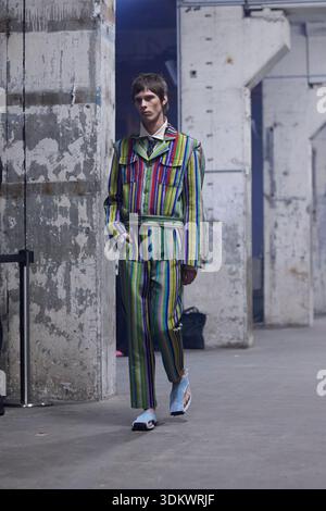 Berlin, Germany, 2nd Feb, 2026. A model walks the runway for the Fall/Winter 2026 collection by Kenneth Ize during Berlin Fashion Week at Kraftwerk. The striking ensemble features a matching two-piece set made from the designer's signature vibrant, multi-colored striped handwoven textile, including a structured utility-style jacket with a collar and matching tailored trousers. The bold patterned look is layered over a white collared shirt with a dark necktie and finished with casual sneakers under industrial lighting. Credit: Felix Wolf/Ģ����ý Live News Stock Photo