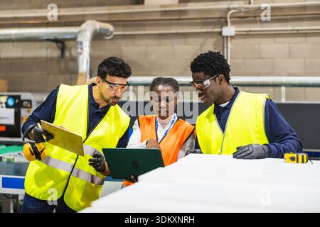 Diverse industrial workers collaborating on a project controlling production Stock Photo