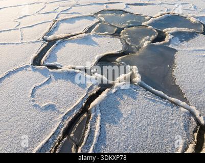 Aerial drone view of beautiful geometric ice floes and frozen patterns on the Baltic Sea surface in winter in Estonia. Stock Photo