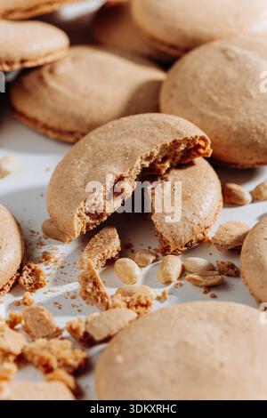 Broken peanut macarons with crumbs and nuts on white background, close up Stock Photo