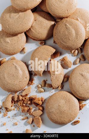 Broken peanut macarons with crumbs and nuts on white background, close up Stock Photo