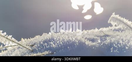 Close-up of sparkling snow and ice in sunlight with a blurred background that the light makes glow in soft colors, rainbow, light refraction on water Stock Photo