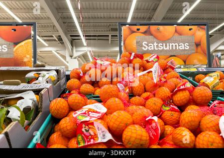 A vibrant display of satsumas piled high in a grocery store, inviting shoppers to explore fresh produce options Stock Photo