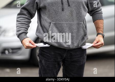 Man showing empty pockets, close-up, the concept of unemployment, bankruptcy or financial crisis Stock Photo
