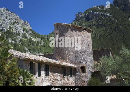 MALLORCA, SPAIN - MAY 15, 2017: Rustic stone building with tower in green subtropical garden in the Tramuntana mountains on May 15, 2017 in Mallorca, Stock Photo