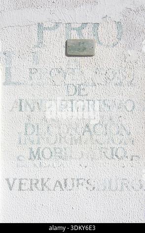 PORT ANDRATX, MALLORCA, SPAIN - AUGUST 5, 2016: Printed unlegible words in various languages on white roughcast wall on August 5 in Port Andratx, Mall Stock Photo