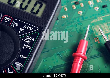 Electronic Testing Probe and Multimeter on PCB Background Stock Photo