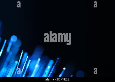 Abstract blue glowing fibers with soft bokeh on dark background. Digital connectivity and internet communication infrastructure concept Stock Photo