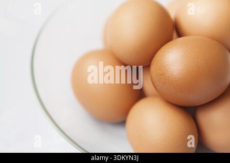 Fresh brown hen's eggs in the glass plate close up Stock Photo