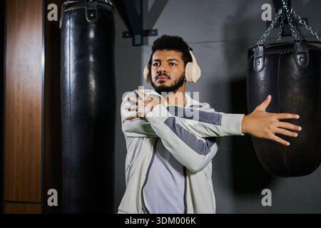 A young african american sportsman stretches his arms while preparing for an intense workout. Stock Photo