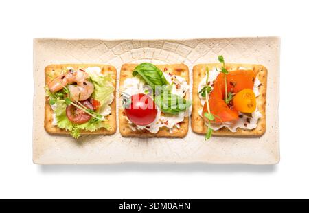 Plate with tasty crackers isolated on white background, closeup Stock Photo