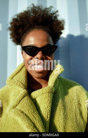 Portrait of Young Adult Black Woman Smiling Confidently in Sunglasses Outdoors Stock Photo