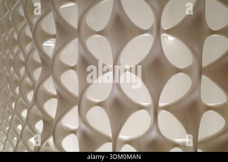 A close up architectural detail of a repeating white geometric lattice with curved organic shapes creating a clean and modern decorative surface. Stock Photo