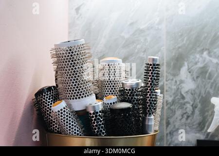 Organizers with different hair brushes on table in beauty salon Stock Photo