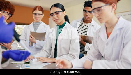Science teacher, students or lesson with demonstration for education or practical learning in class. Group, learners and watching instructor with Stock Photo