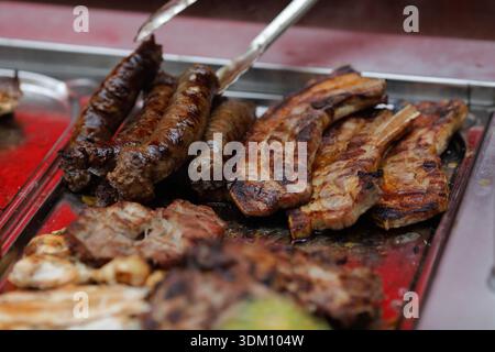 Details with various types of grilled meat in a farmers market. Stock Photo