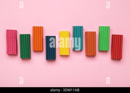 Multi-colored plasticine bricks on pink background. Children's plasticine close-up. Stock Photo