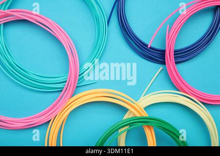 3d pen for creating volume plastic figures on blue background. Top view Stock Photo
