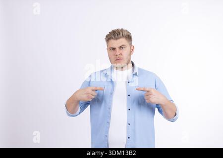 Happy young man pointing fingers at himself with pride Stock Photo