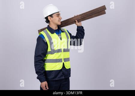 Worker carrying wooden plank on his shoulder in studio Stock Photo
