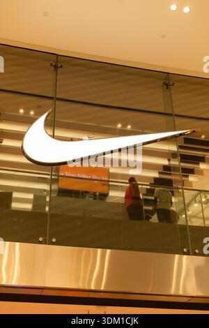 Singapore - January 27, 2026: Visitors look at sports gear inside a Nike store in Singapore. The store features a large Nike logo and a modern design. Stock Photo