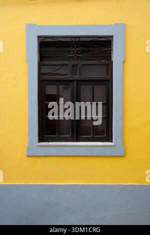 Bright yellow wall with grey window frame Stock Photo