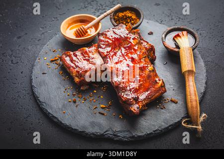 Barbecue pork spare ribs with spices and honey as top view on an old rustic board with copy space Stock Photo