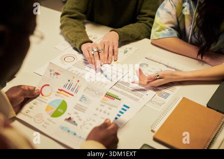 Diverse Young People Collaborating on Business Analytics at Office Table Stock Photo