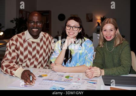 Diverse Group of Adult and Young Colleagues Analyzing Charts Stock Photo