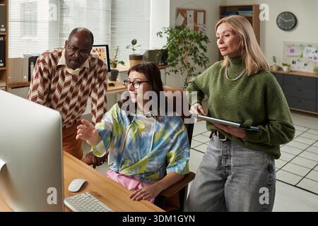 Diverse Adult Team Collaborating on Project in Office Setting Stock Photo