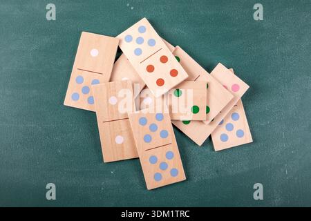Wooden Domino Tiles Scattered On Green Surface Showing Colorful Dots And Natural Texture Stock Photo