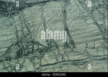 Natural green granite stone surface with dark mineral veins Stock Photo