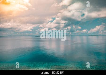 Radiant Maldives aerial open ocean dramatic sky clouds stunning reflection immersive serene calm sea water paradise travel destination seascape views Stock Photo