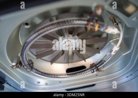 Macro dishwasher interior showing spray arm and central filter assembly in stainless steel basin, water Stock Photo