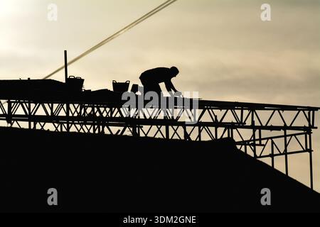 A builder working on scaffolding on a private house about to undergo renovation to a extension to the property Stock Photo