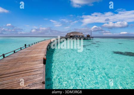Maldives overwater pier brilliant sunshine, majestic cloudscape, luxury water villas, breathtaking summer tropical vacation landscape. Tropical ocean Stock Photo