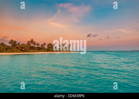 Tropical island sunset glowing horizon, serene ocean, dramatic clouds, meditative nature landscape, dreamy summer escape Stock Photo