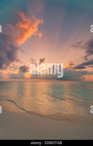 Radiant sunset ocean beach closeup with peaceful waves and colorful sky clouds tranquil horizon sun rays pristine summer travel nature background Stock Photo