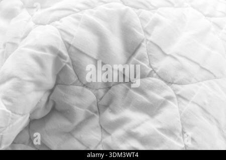 White quilted fabric show curved shapes and subtle stitching, offering a calm, cozy texture ideal for backgrounds, textiles, and home decor visuals Stock Photo