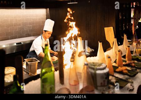 Live Asian kitchen chef cooking with fire dynamic restaurant culinary action food photography Stock Photo