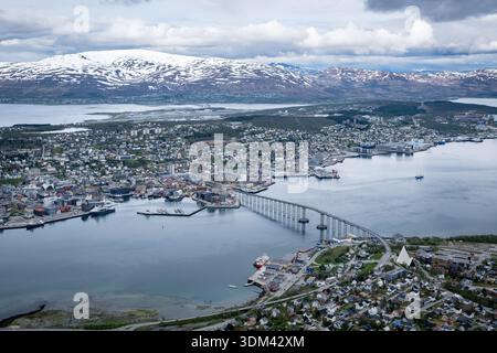 High angle panorama from Storsteinen mountain shows center of Tromsø, Norway, with the long Tromsø Bridge connecting Tromsøya island to the mainland Stock Photo